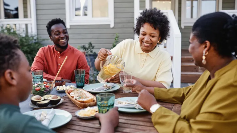 Family seated around table outside enjoying a meal 